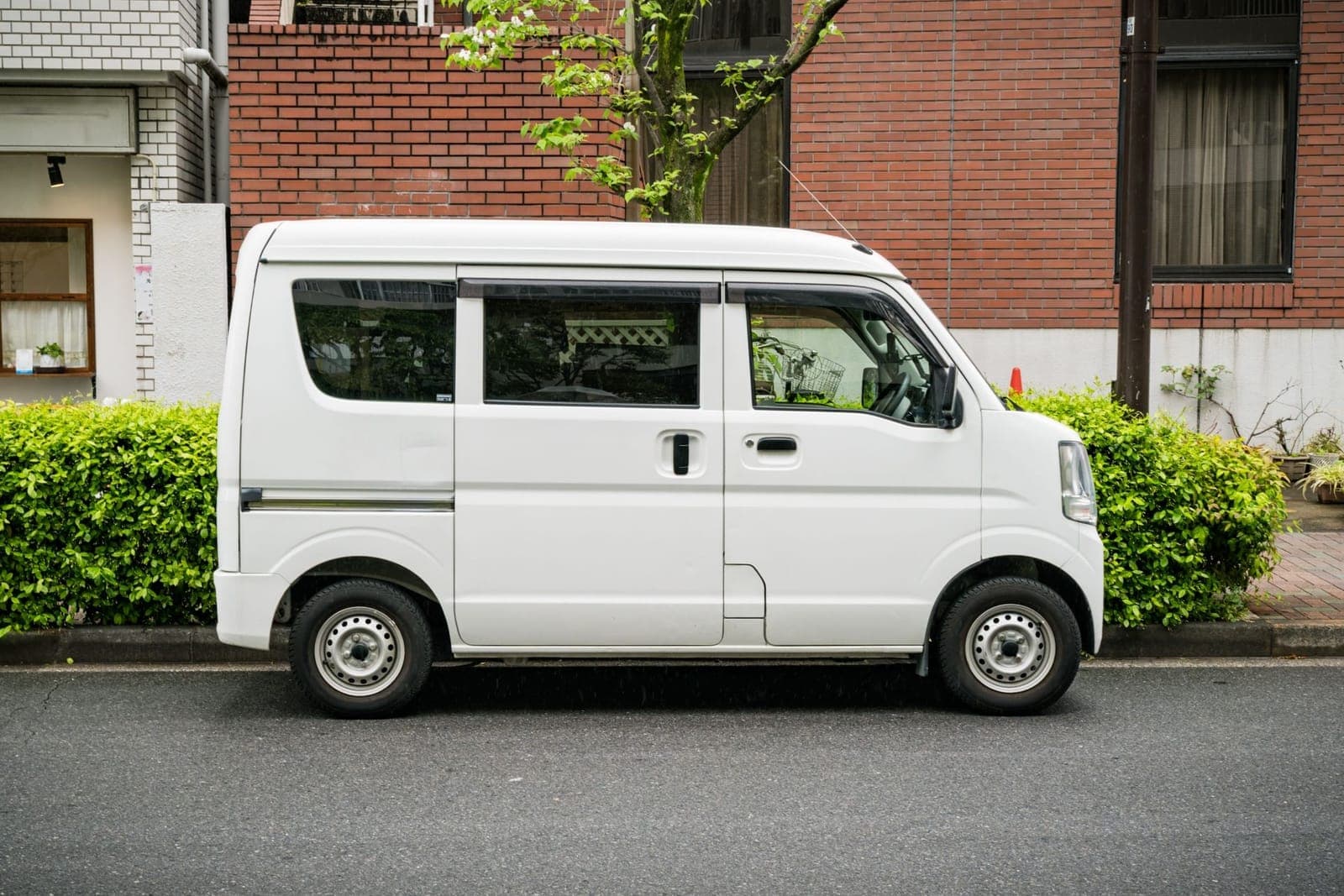 路肩に停まっている白い軽箱バン