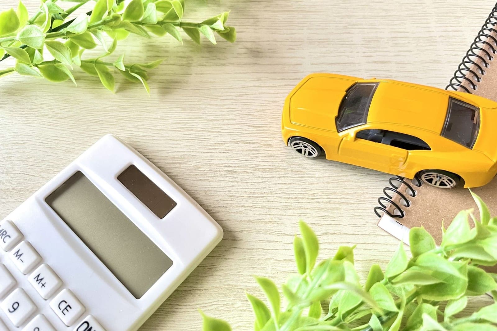 電卓とミニカー。お車にかかる費用のイメージ